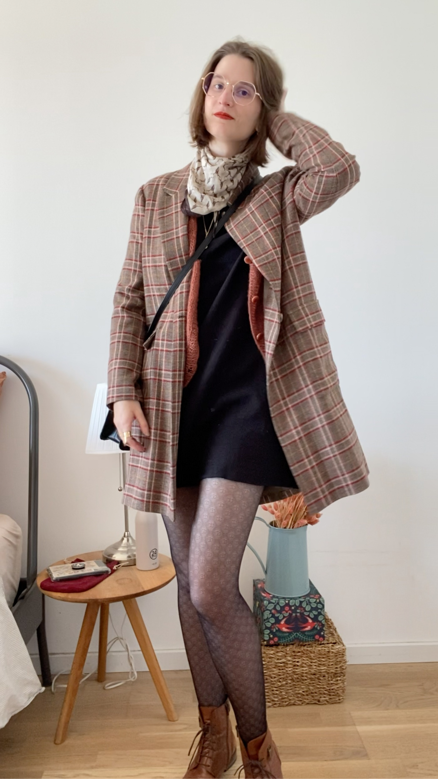 Photographie d'une femme portant une robe noir et un gilet terracotta tricoté main et une veste à carreaux